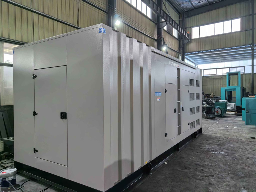 Grey soundproof generator canopy with ventilation louvre panels and access doors in a factory building